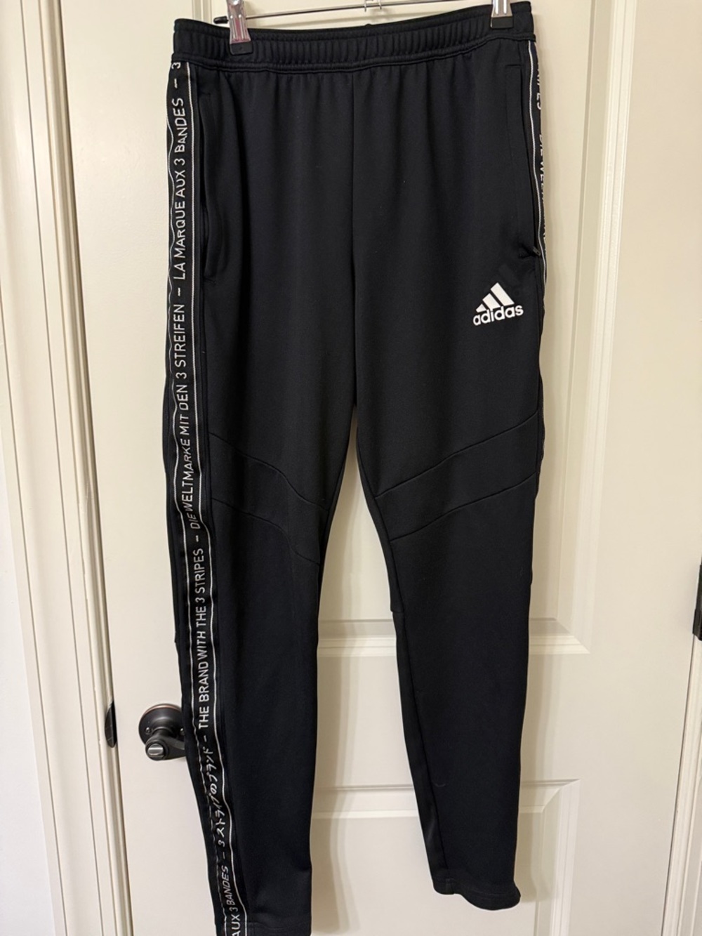 adidas Black Jogger Pants with White Logo and Side Taper. Zipper pockets.